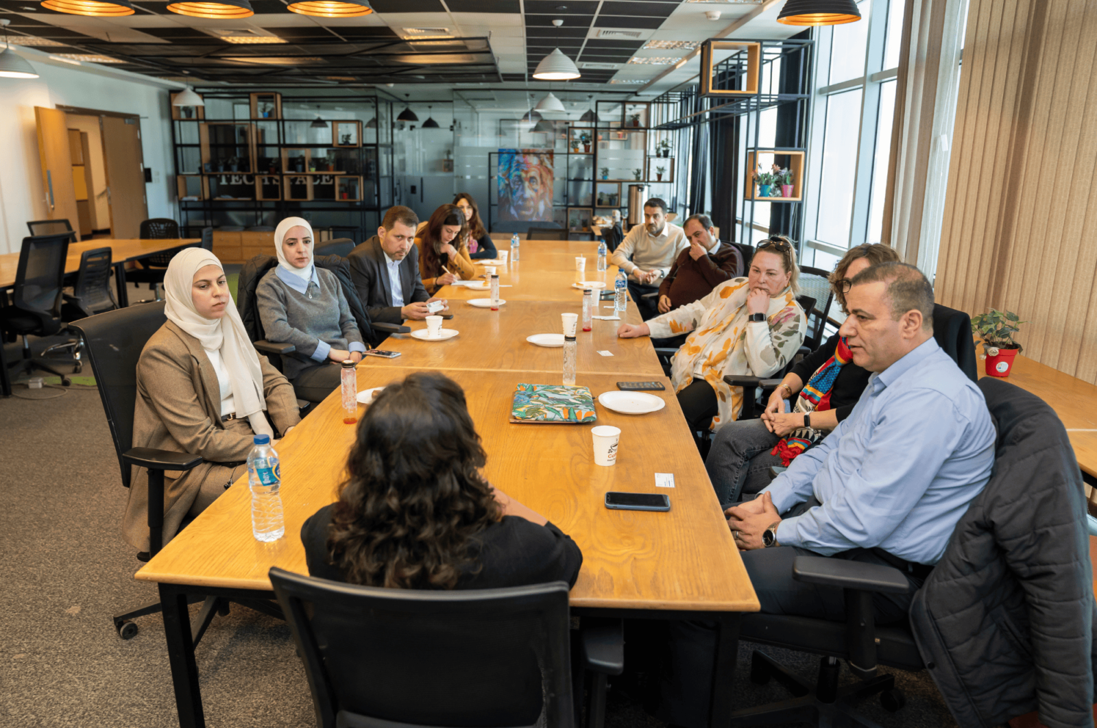 a group of people setting around a round table in a meeting